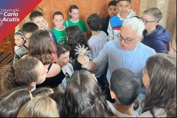 Dom Alessandro Ruffinoni mostra relíquia de Carlo Acutis a adolescentes.
