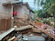 Equipe da Cáritas RS ajudando na limpeza de uma casa enlameada pela enchente no Rio Grande do Sul