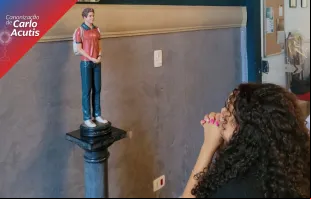 Jovem reza diante da imagem de Carlo Acutis na paróquia que será dedicada a ele