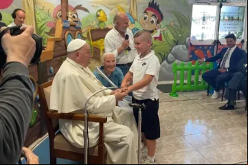 Papa Francisco cumprimenta menino ao lado da irmã Geneviève Jeanningros