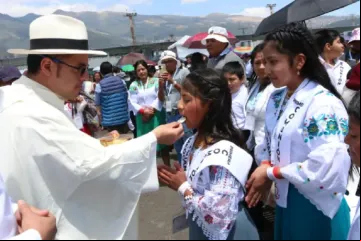 Padre dá a comunhão a crianças  no Congresso Eucarístico Internacional 2024