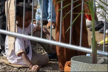 Criança sentada em papelão assiste a missa celebrada hoje pelo papa Francisco em Timor-Leste