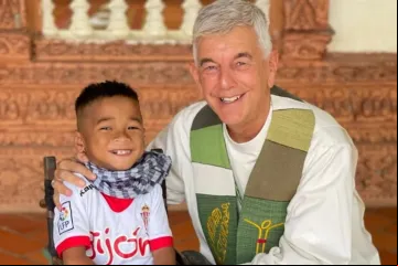 O padre "Kike" Figaredo com uma das crianças deficientes que ajuda no Camboja