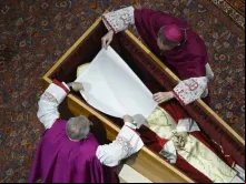 Dom Georg Gänswein e dom Giovanni Ravelli colocam um pano branco sobre o rosto do papa Bento XVI no funeral do papa na basílica de São Pedro, no Vaticano, em 4 de janeiro de 2023.