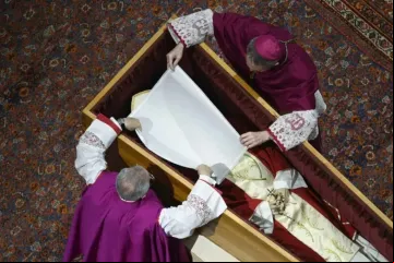 Dom Georg Gänswein e dom Giovanni Ravelli colocam um pano branco sobre o rosto do papa Bento XVI no funeral do papa