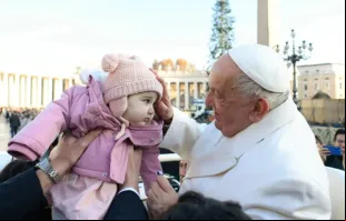Papa Francisco abençoa bebê em audiência geral no Vaticano.