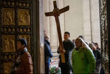 Peregrinos cruzam a porta santa da basílica de São Pedro