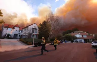 Bombeiros correm enquanto incêndio florestal atinge ontem (7) Pacific Palisades, Califórnia, EUA.  Um incêndio florestal de rápido avanço num subúrbio de Los Angeles queimou prédios e causou evacuações enquanto ventos "com risco de morte" atingiam a região.