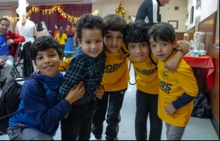 Filhos de imigrantes afegãos brincam em festa de fim de ano em St. Louis, Missouri, EUA, em 9 de dezembro de 2023.