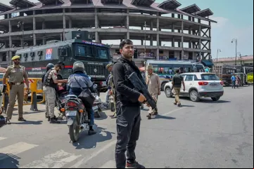 Policial guarda posto de controle em rua de Srinagar