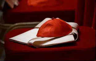 Um zucchetto, o solidéu vermelho usado pelos cardeais.