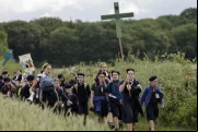 Jovens seguram cruzes ao chegarem para a missa na tradicional peregrinação de Pentecostes de Paris a Chartres, em Sonchamp, perto de Paris, no último domingo (8).