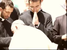 O papa Francisco beija as mãos de um grupo de sacerdotes recém-ordenados