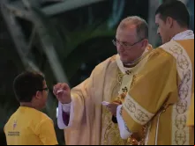 Menino recebe a primeira comunhão.