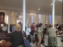 Multidões saem da Igreja Católica da Santíssima Trindade em Washington, DC, após a "Missa do Orgulho" de 14 de junho de 2023, com bandeiras LGBT visíveis na igreja. -  Pedro Pinedo