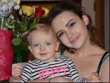 Anahi junto com o bebê que quer adotar com o seu esposo.