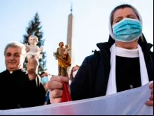 Um sacerdote e uma religiosa durante a bênção do Menino Jesus.