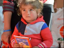 Uma menina síria segurando uma Bíblia.