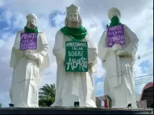 Cartazes pró-aborto colocados nas estátuas dos Reis Magos.
