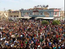 Cristãos iraquianos esperam do lado de fora da igreja para celebrar a Páscoa.
