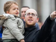 Pai participa com o seu filho da oração do Ângelus na Praça de São Pedro, no Vaticano.