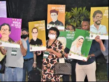 Participantes mostram retratos de santo Oscar Romero e dos chamados 'mártires da caminhada'.