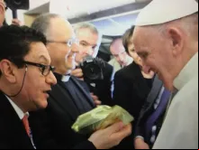 O jornalista Néstor Ponguta entrega uma bolsa de café ao Papa no voo que o leva a Cuba.