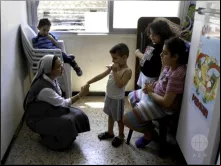 Irmã Annie Demerijan, colaboradora de Ajuda à Igreja que Sofre na Síria, junto com crianças cristãs em Aleppo.