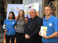 Flávia Fontes e Dom Orani Tempesta entre dois voluntários pioneiros dos Jogos.