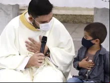 Padre Artur Oliveira reza com João Miguel 