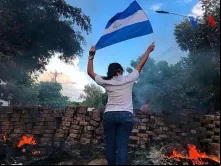 Uma mulher com a bandeira da Nicarágua em uma barricada durante os protestos de abril de 2018,