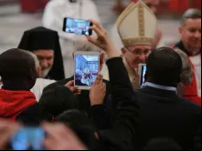 Papa em uma celebração rodeado por celulares.