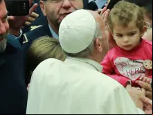 Papa saúda uma criança durante a Audiência.