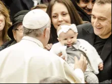 Papa abençoa uma menina na audiência.