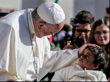 Papa abençoa uma menina ao início da Audiência Geral.