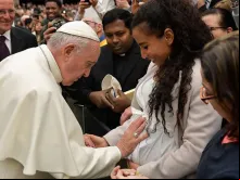 Papa abençoa um bebê no ventre de sua mãe.