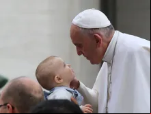 Papa Francisco saúda um menino no Vaticano.