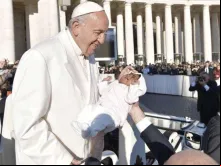Papa abençoa uma criança em uma Audiência Geral.