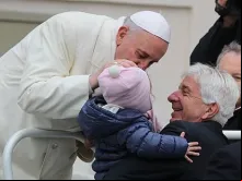 O Papa Francisco beija uma pequena em uma audiência geral em São Pedro
