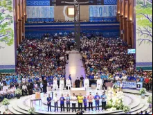 homens rezam o terço no Altar Central da Basílica de Aparecida.