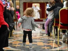 Menina caminha em direção ao papa Francisco em audiência hoje (13