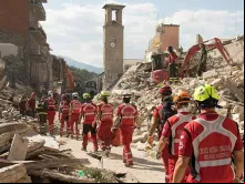 Equipe de resgate da Cruz Vermelha em meio aos escombros após terremoto na Itália.