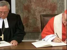 Cardeal Cassidy e o bispo luterano Christian Krause assinam declaração conjunta.