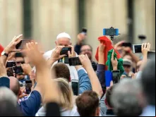 Papa Francisco no Vaticano cercado por pessoas com seus celulares.